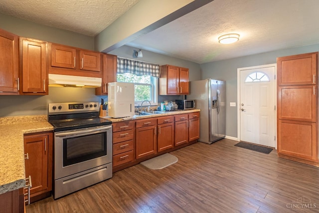 819 E Main St, West Union, OH 45693 - kitchen with stainless steel appliances, under cabinet range hood, a textured ceiling, dark wood-style floors, and light countertops