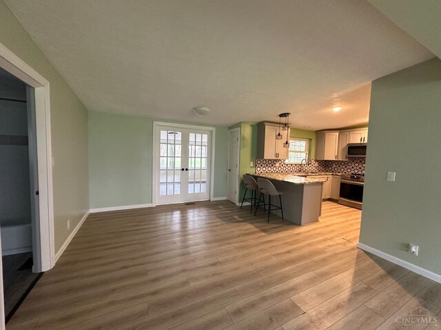 41 Wolfer Dr, Batavia Twp, OH 45102 - kitchen featuring tasteful backsplash, a kitchen breakfast bar, light wood-type flooring, a peninsula, and stainless steel appliances