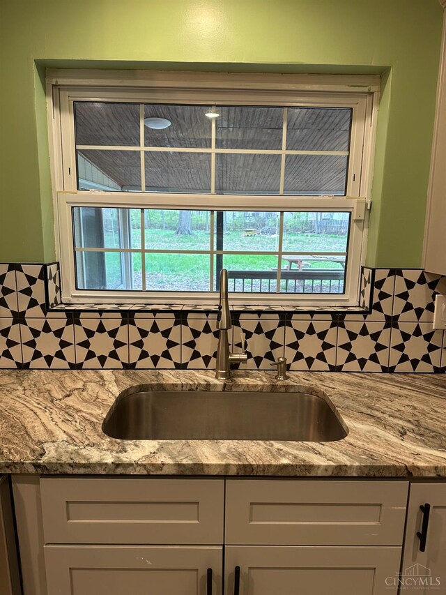 41 Wolfer Dr, Batavia Twp, OH 45102 - kitchen featuring a sink, tasteful backsplash, a wealth of natural light, and light stone countertops