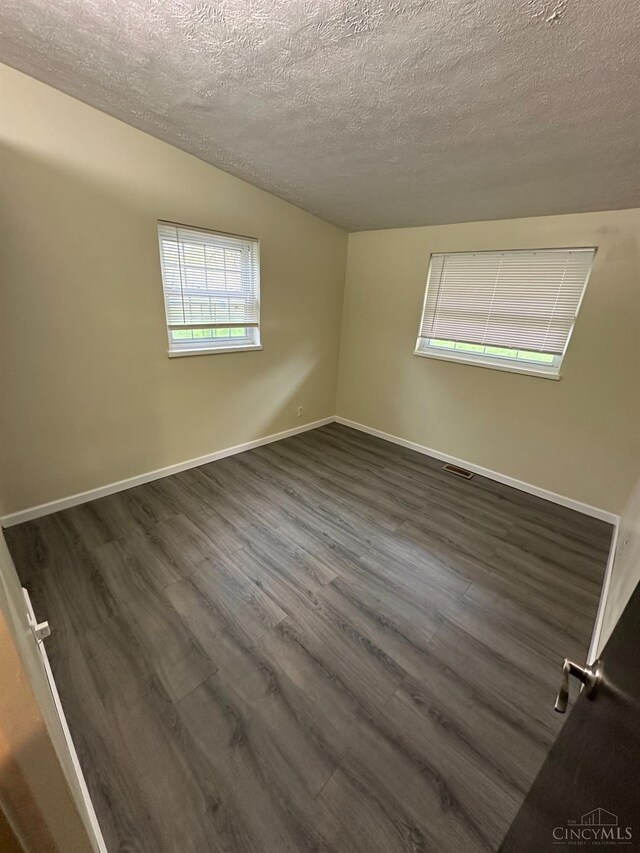 41 Wolfer Dr, Batavia Twp, OH 45102 - unfurnished room with visible vents, a textured ceiling, baseboards, and dark wood finished floors