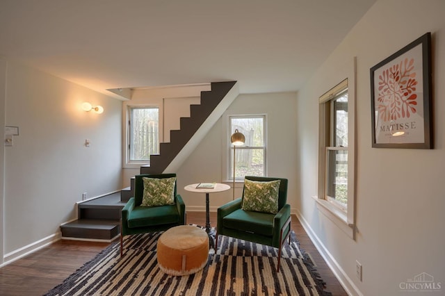 sitting room featuring wood finished floors, a healthy amount of sunlight, and stairs