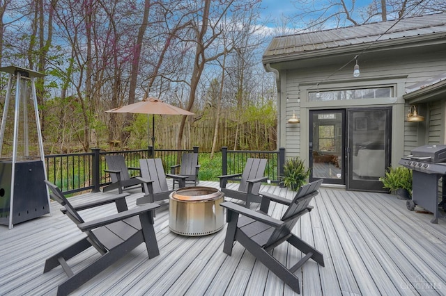 deck with a fire pit and area for grilling