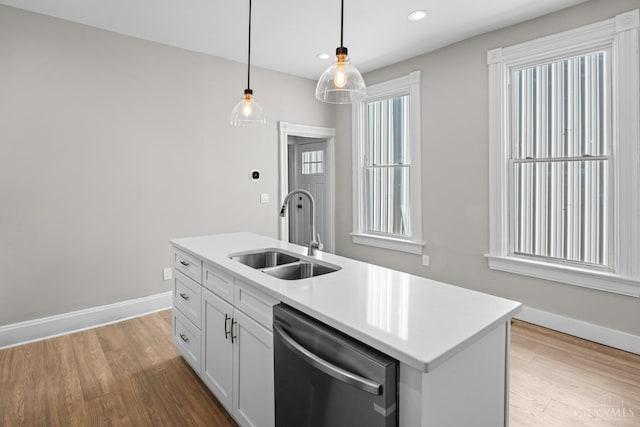 1318 Knowlton St, Cincinnati, OH 45223 - kitchen featuring hanging light fixtures, light wood finished floors, stainless steel dishwasher, and a sink