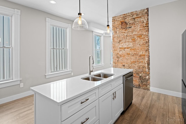 1318 Knowlton St, Cincinnati, OH 45223 - kitchen with stainless steel dishwasher, decorative light fixtures, a sink, and light wood-style floors