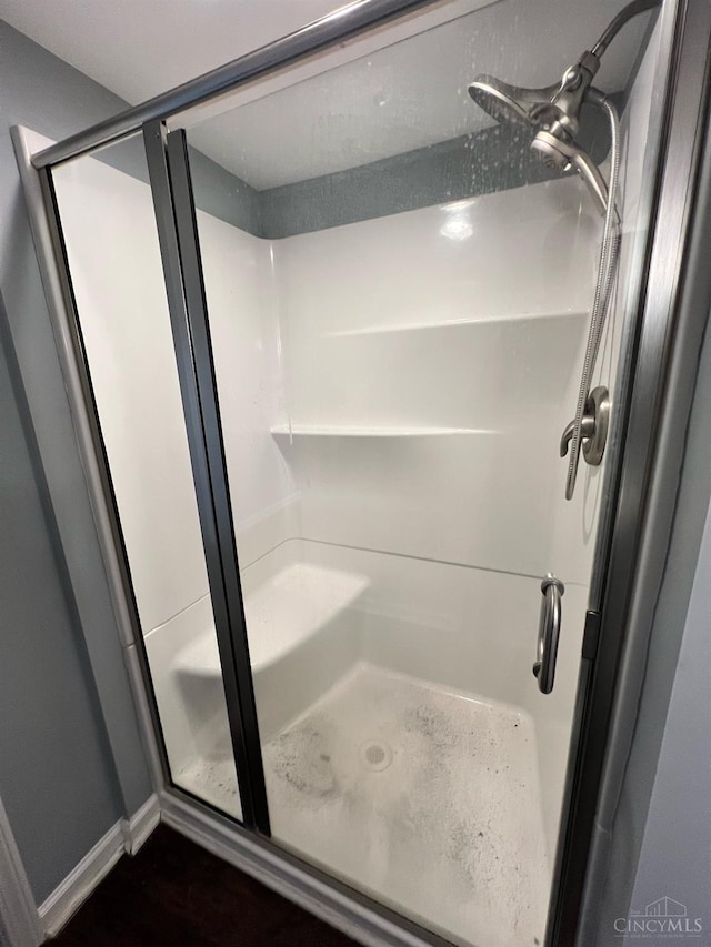 full bathroom featuring baseboards and a shower stall