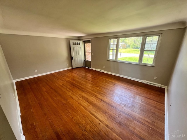 spare room with visible vents, dark wood finished floors, and baseboards