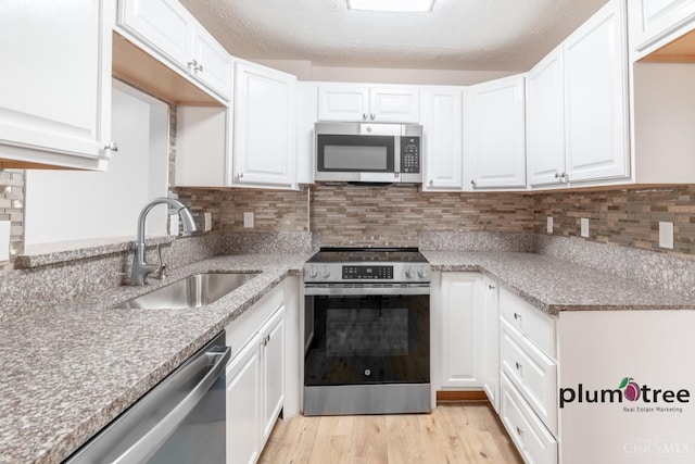 3640 Westwood Northern Blvd Unit 24, Cheviot, OH 45211 - kitchen with tasteful backsplash, white cabinetry, a sink, and appliances with stainless steel finishes