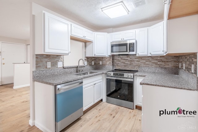 3640 Westwood Northern Blvd Unit 24, Cheviot, OH 45211 - kitchen with visible vents, white cabinets, a sink, appliances with stainless steel finishes, and light wood-style floors