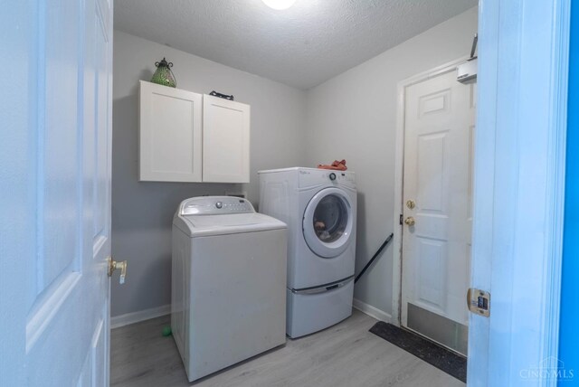 10701 Stone Ridge Way, Harrison, OH 45030 - washroom with a textured ceiling, baseboards, light wood-style floors, cabinet space, and washer and dryer