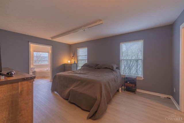 10701 Stone Ridge Way, Harrison, OH 45030 - bedroom featuring light wood-type flooring, ensuite bath, and baseboards
