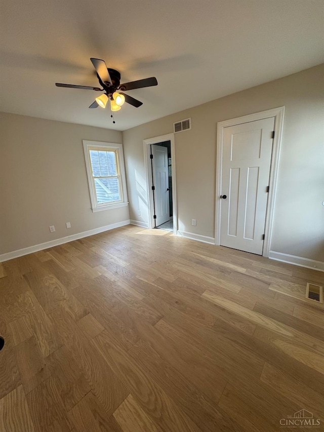 spare room with visible vents, light wood-style floors, and ceiling fan