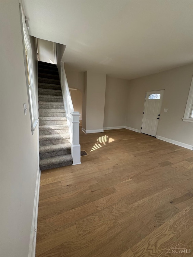 entryway with stairway, baseboards, and wood finished floors