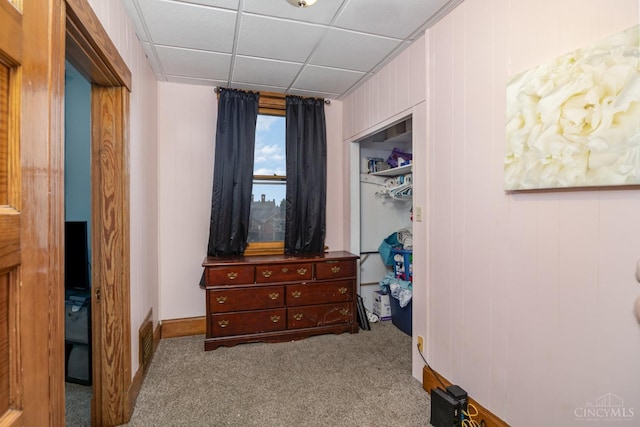 carpeted bedroom featuring baseboards, a drop ceiling, visible vents, and a closet