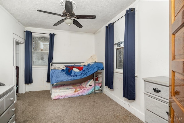carpeted bedroom featuring ceiling fan and a textured ceiling