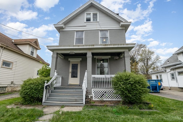 american foursquare style home with brick siding and a porch