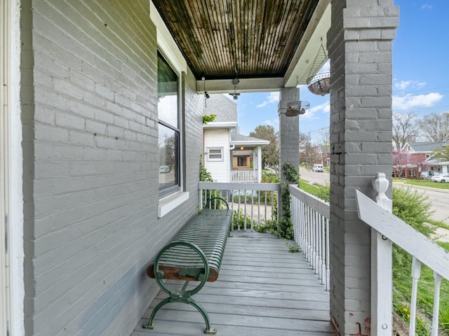 wooden terrace with a ceiling fan and covered porch
