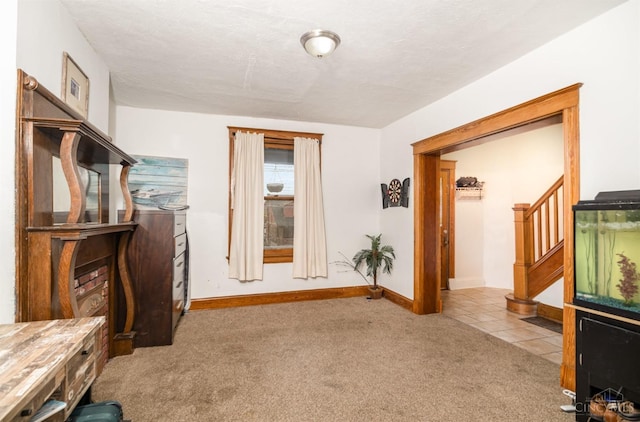 unfurnished office featuring carpet floors, tile patterned floors, and baseboards