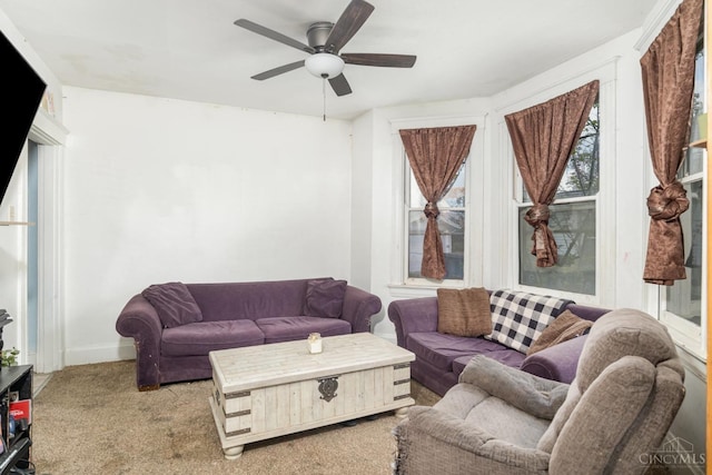 carpeted living room with ceiling fan and baseboards