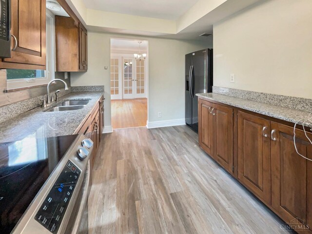 7046 Beechmont Ave, Anderson Twp, OH 45230 - kitchen with stainless steel range with electric stovetop, fridge with ice dispenser, a sink, and light wood-style flooring