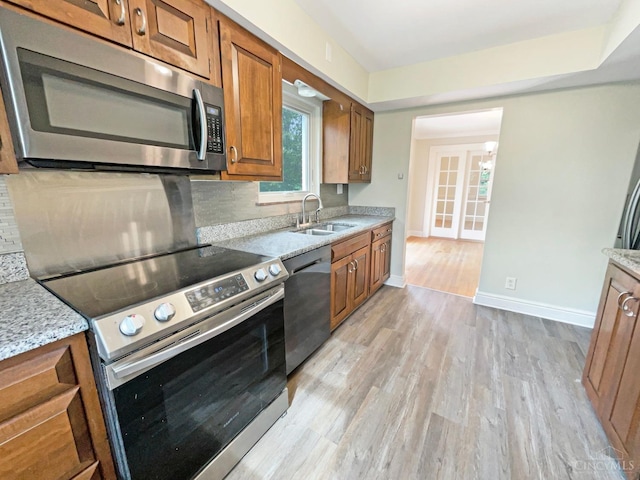 7046 Beechmont Ave, Anderson Twp, OH 45230 - kitchen featuring appliances with stainless steel finishes, a sink, brown cabinetry, light wood finished floors, and baseboards