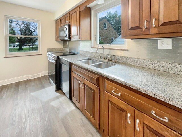 7046 Beechmont Ave, Anderson Twp, OH 45230 - kitchen featuring appliances with stainless steel finishes, a sink, light wood finished floors, and plenty of natural light