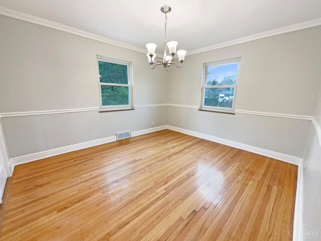 7046 Beechmont Ave, Anderson Twp, OH 45230 - spare room featuring a chandelier, light wood-style floors, crown molding, and baseboards