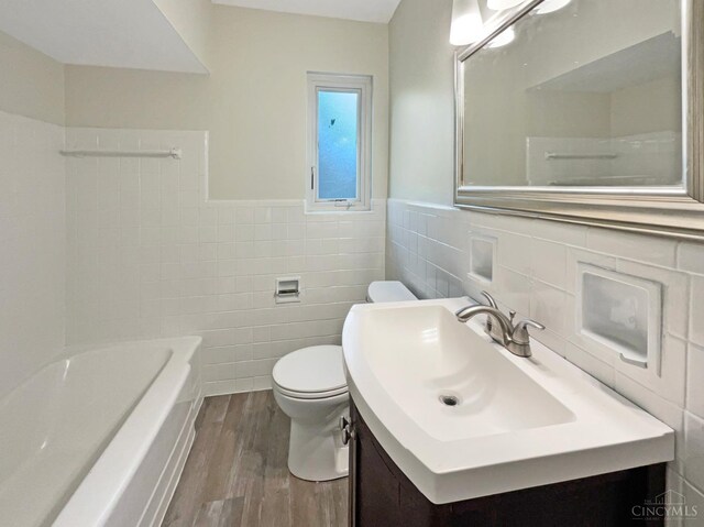 7046 Beechmont Ave, Anderson Twp, OH 45230 - full bathroom with tile walls, wood finished floors, a bath, vanity, and toilet