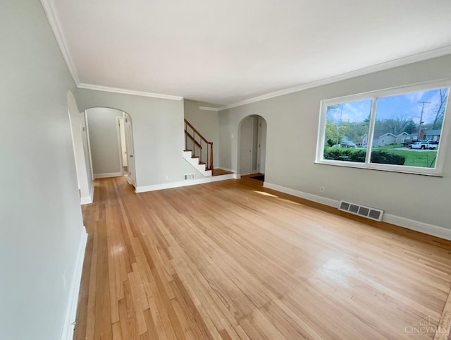 7046 Beechmont Ave, Anderson Twp, OH 45230 - unfurnished room featuring arched walkways, crown molding, light wood-type flooring, stairs, and baseboards