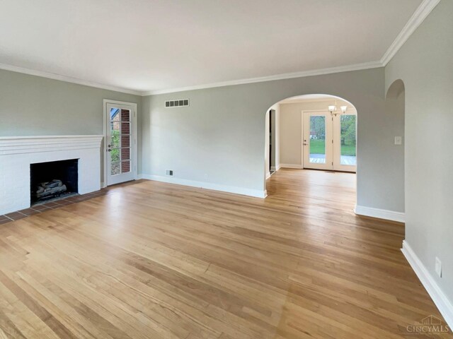 7046 Beechmont Ave, Anderson Twp, OH 45230 - unfurnished living room featuring arched walkways, plenty of natural light, light wood-style flooring, crown molding, and baseboards