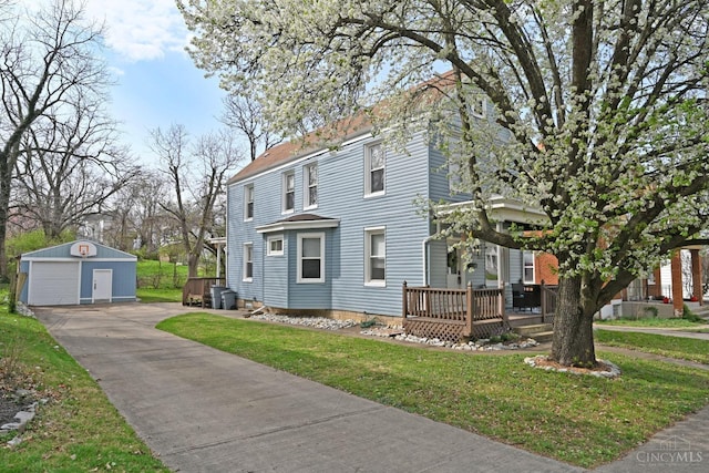 view of front of property with an outdoor structure, a wooden deck, a front yard, and a garage