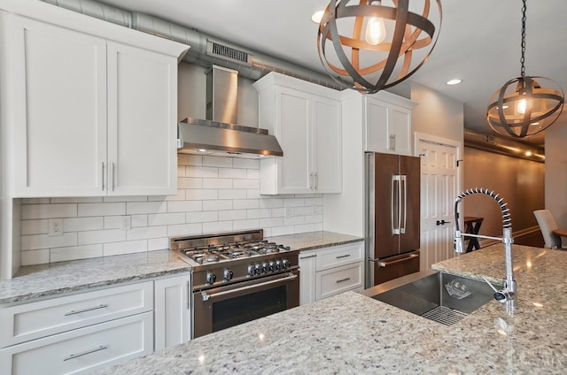 1308 Broadway St Unit 2, Cincinnati, OH 45202 - kitchen with high end appliances, wall chimney range hood, a sink, white cabinetry, and backsplash
