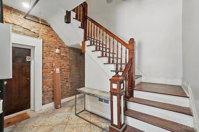 1308 Broadway St Unit 2, Cincinnati, OH 45202 - staircase featuring brick wall, baseboards, and lofted ceiling