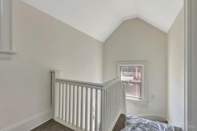 stairway with vaulted ceiling, carpet floors, and baseboards