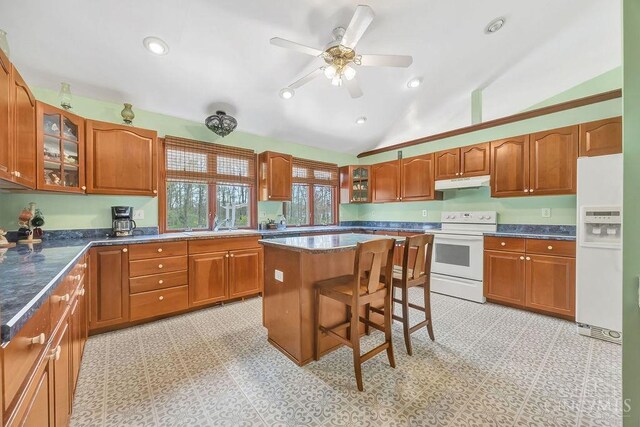 4092 Snowhill Rd, Perry Twp, OH 45118 - kitchen with vaulted ceiling, glass insert cabinets, white appliances, under cabinet range hood, and a breakfast bar area
