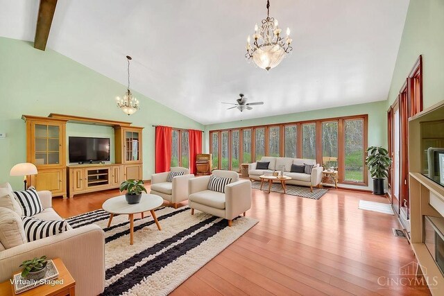 4092 Snowhill Rd, Perry Twp, OH 45118 - living room with ceiling fan with notable chandelier, beam ceiling, wood finished floors, and high vaulted ceiling