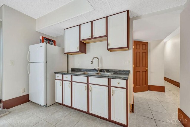 4092 Snowhill Rd, Perry Twp, OH 45118 - kitchen featuring dark countertops, freestanding refrigerator, a sink, and light tile patterned floors