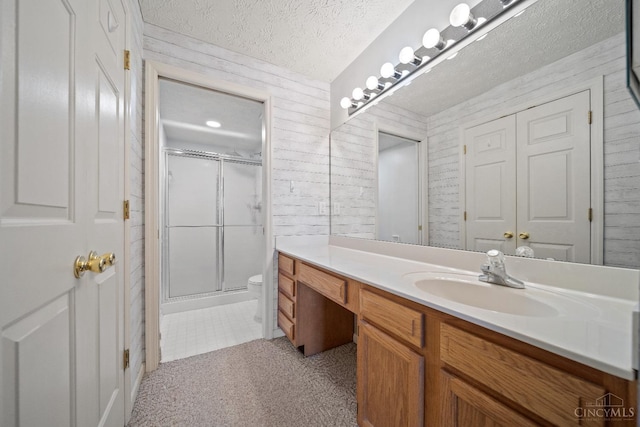 bathroom featuring vanity, toilet, and a stall shower