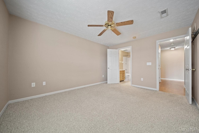 unfurnished bedroom with carpet flooring, a textured ceiling, and visible vents