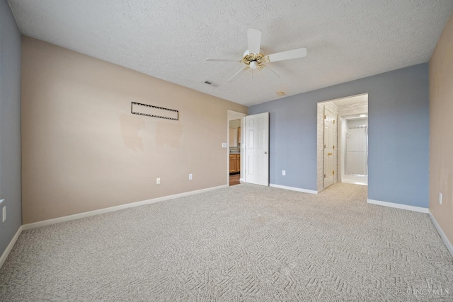 unfurnished bedroom featuring baseboards, visible vents, carpet, and a textured ceiling