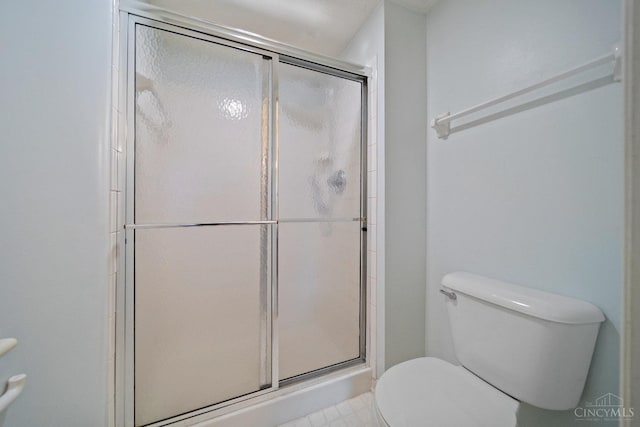 full bathroom featuring a stall shower and toilet