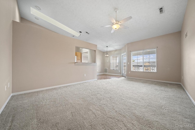 carpeted spare room featuring baseboards, visible vents, a textured ceiling, and ceiling fan