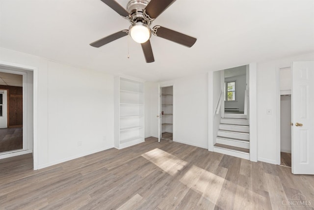 unfurnished bedroom featuring a ceiling fan, light wood-style flooring, and baseboards