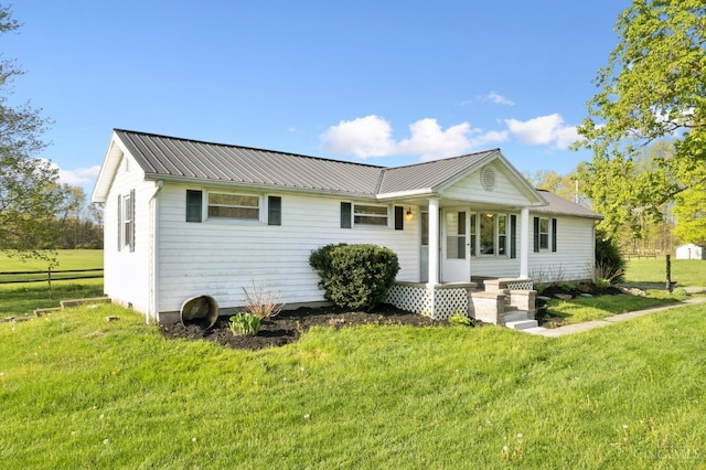 view of front of house featuring a front lawn and metal roof