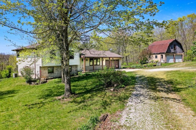 6139 N State Route 48, Clearcreek Twp, OH 45036 - view of front facade featuring dirt driveway, a front yard, a porch, and a garage