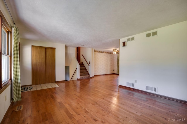 6139 N State Route 48, Clearcreek Twp, OH 45036 - unfurnished room with hardwood / wood-style flooring, stairway, baseboards, and a textured ceiling
