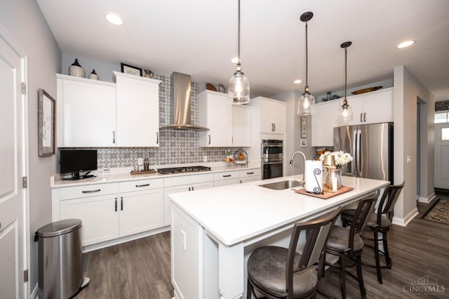 5038 Maiden Way, Liberty Twp, OH 45011 - kitchen with wall chimney range hood, appliances with stainless steel finishes, a kitchen island with sink, backsplash, and white cabinets