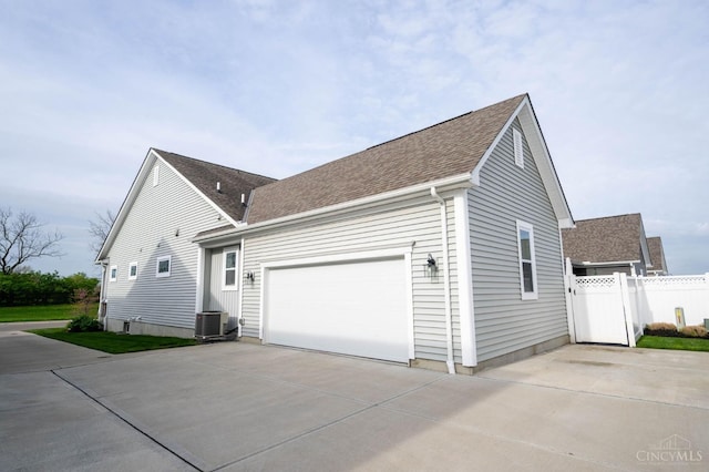 5038 Maiden Way, Liberty Twp, OH 45011 - view of home's exterior featuring concrete driveway, fence, a shingled roof, an attached garage, and cooling unit