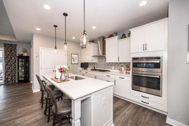 5038 Maiden Way, Liberty Twp, OH 45011 - kitchen featuring a sink, wall chimney range hood, stainless steel appliances, a kitchen island with sink, and backsplash