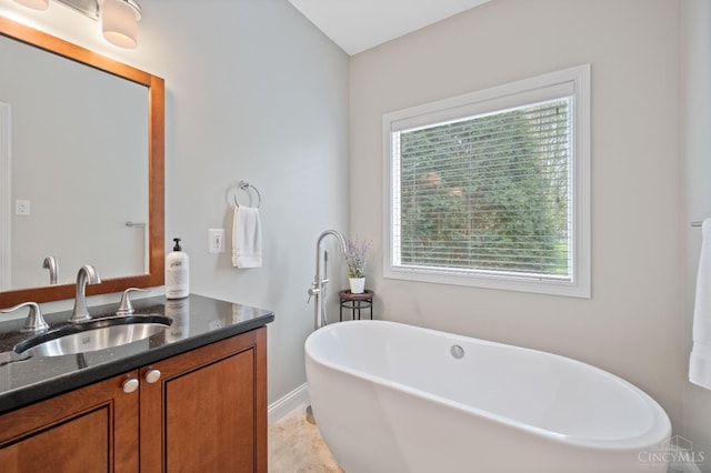 bathroom with a freestanding tub and vanity
