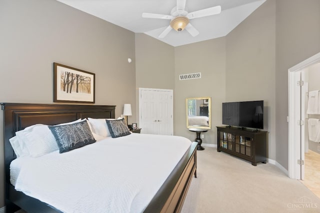bedroom with visible vents, a closet, light carpet, baseboards, and high vaulted ceiling